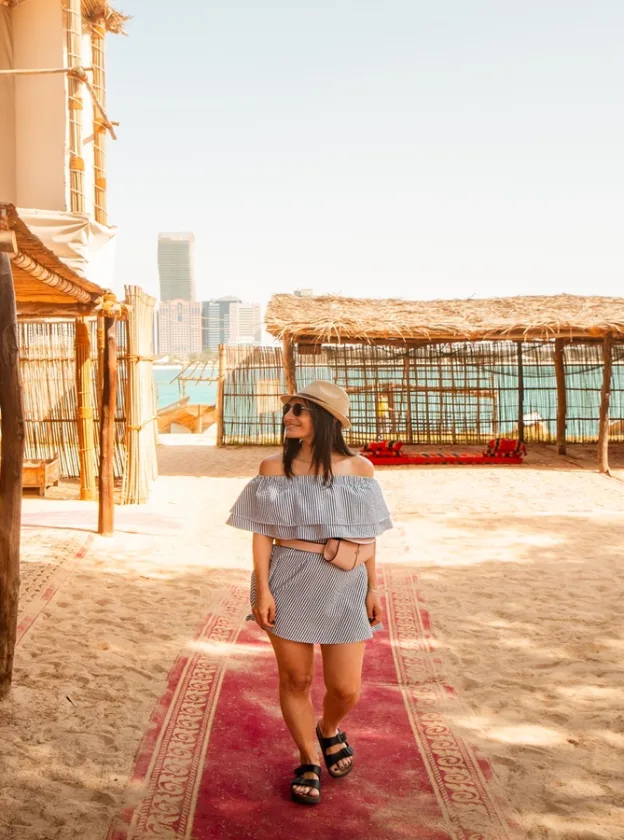 Visitor at the Heritage Village in Abu Dhabi, with the city skyline behind