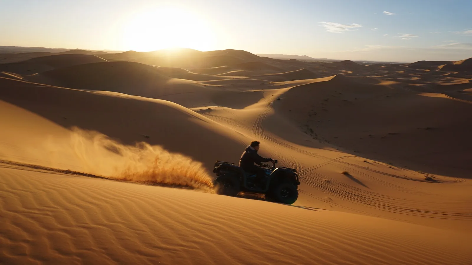 Tourist riding a quad bike across the golden desert dunes during the Quad Bike Tour in Abu Dhabi