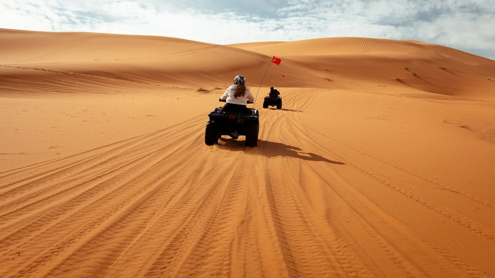 Quad biking across the golden sand dunes in the Abu Dhabi desert during an exciting desert adventure