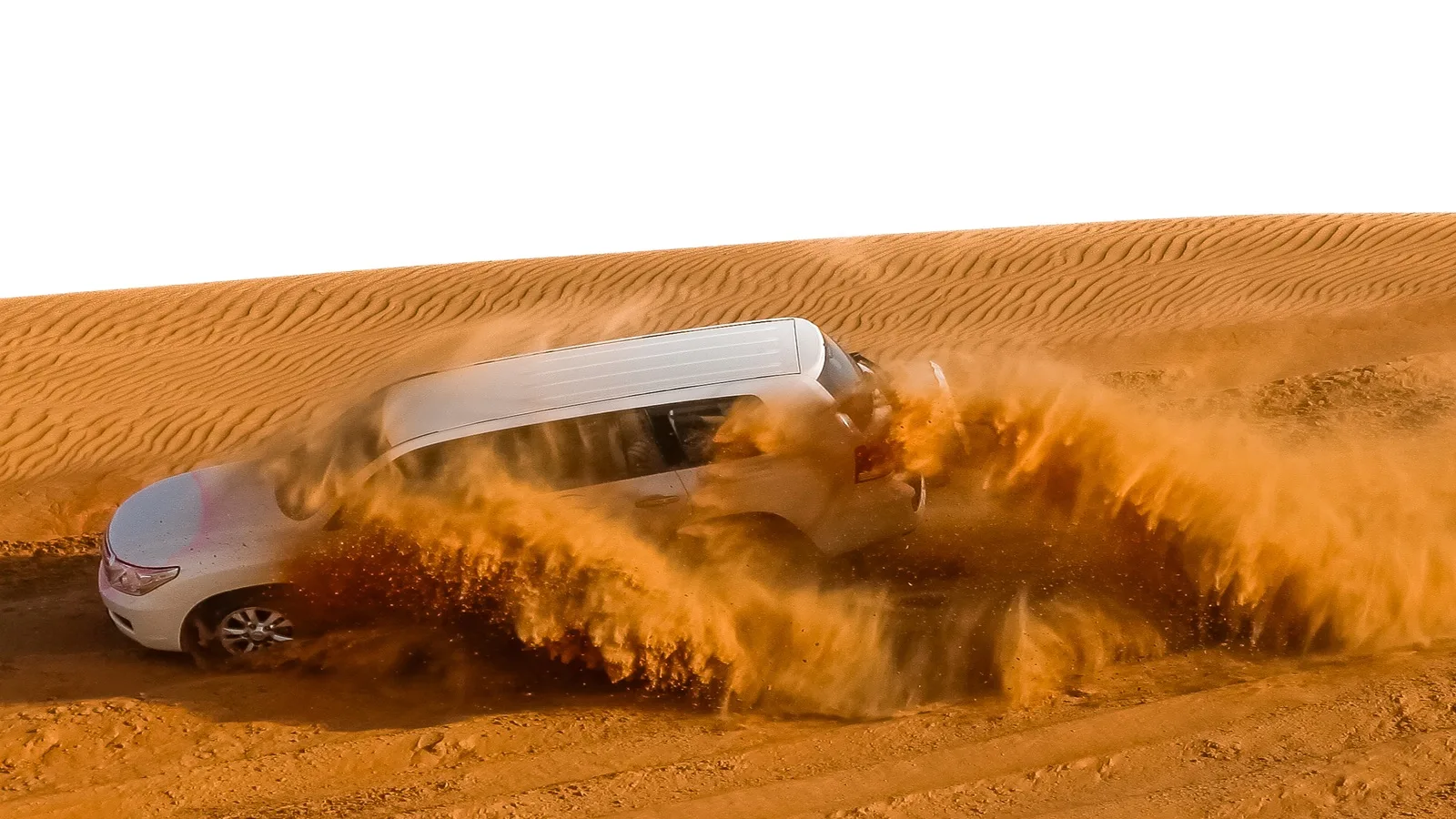 4x4 vehicle driving across the towering golden dunes of the Liwa Desert during a desert