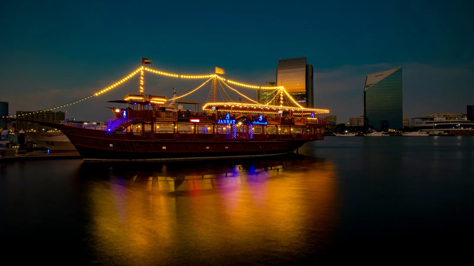 Traditional dhow cruise sailing along Abu Dhabi Corniche with the city skyline in the background