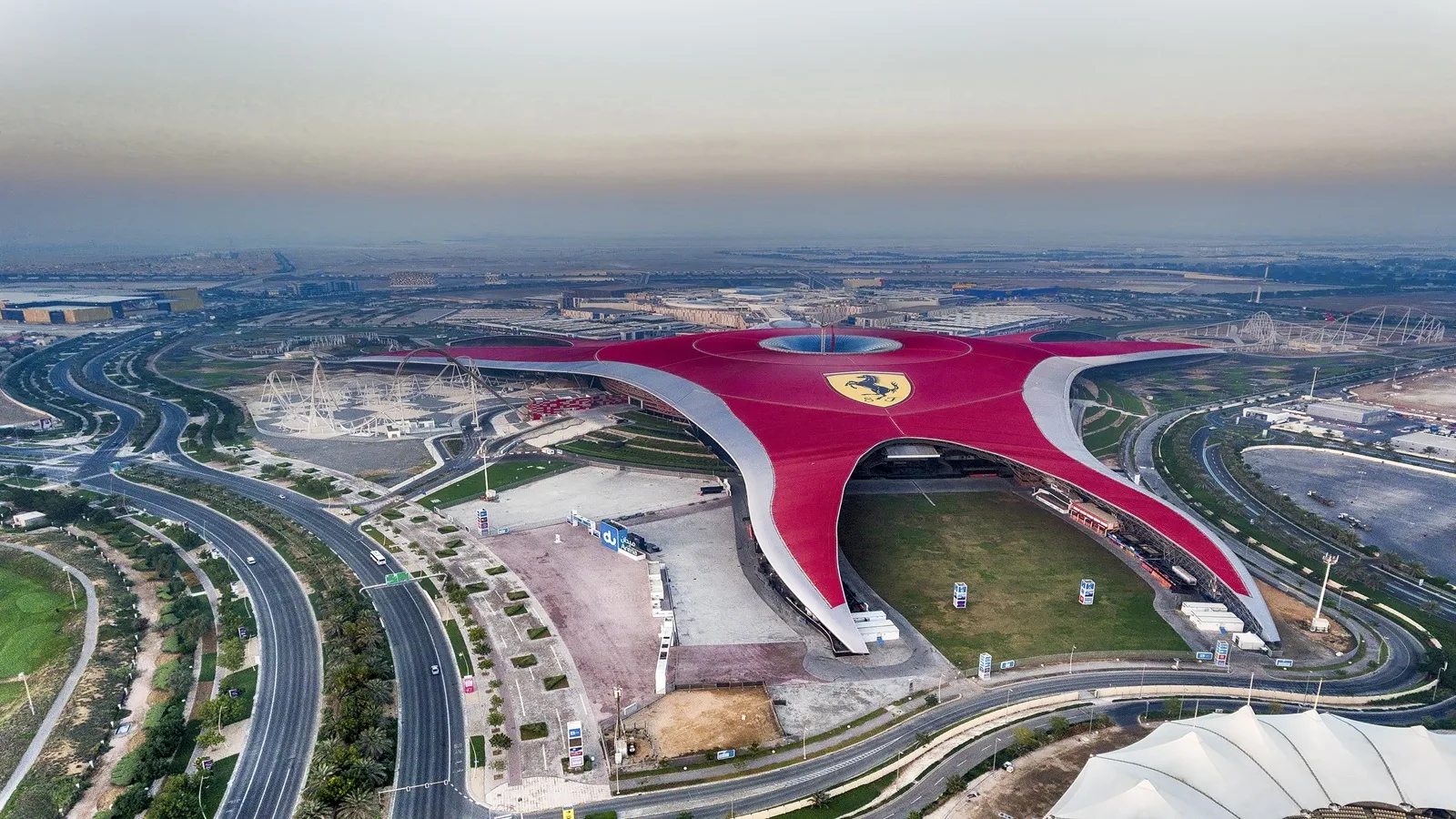 Exterior view of Ferrari World Abu Dhabi featuring its iconic red roof and Ferrari logo on Yas Island