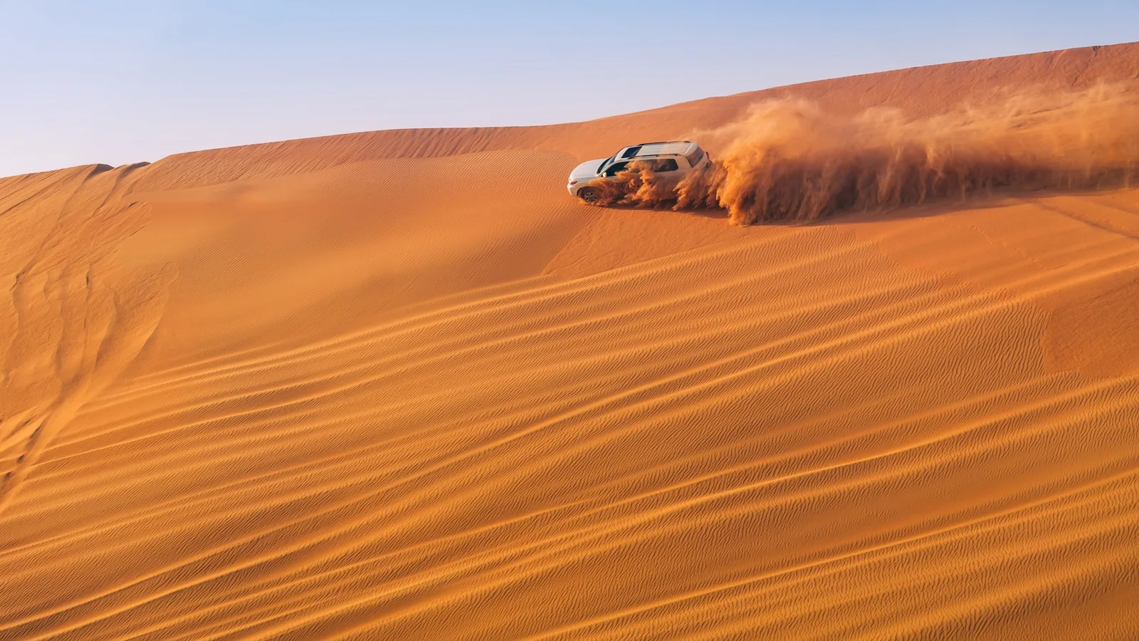 4x4 vehicle dune bashing across the golden dunes during a Morning Desert Safari in Abu Dhabi